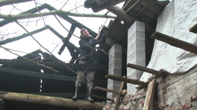 Волонтер Святослав Петрошенко обрізає дерево, яке пошкодило дах складу для їжі у Хмельницькому
