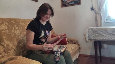 Майстриня показує батькові вироби з бісеру Майстриня показує батькові вироби з бісеру