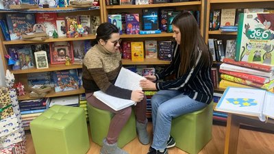 Наталя Журихіна читає книжку, написану шрифтом Брайля