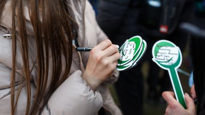 Учасники акції підписують таблички своїм іменем поруч із деревом Учасники акції підписують таблички своїм іменем поруч із деревом