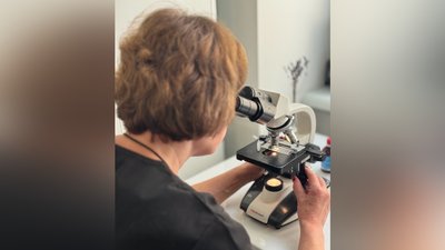 Медикиня працює з мікроскопом