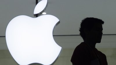 Силует людини на фоні лого компанії Apple
