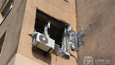 Розбите вікно внаслідок влучання російського дрона у вікно багатоповерхівки
