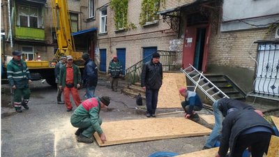 Комунальники закривають розбиті вибуховою хвилею вікна Комунальники закривають розбиті вибуховою хвилею вікна