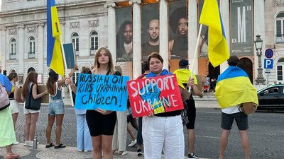 Дівчина з Нової Каховки малює плакати для мітингів у Лісабоні