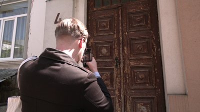 Ілля Сигачов фотографує старі дерев'яні двері у Рівному на вулиці Поштовій