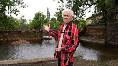 Житель Херсона показує свій будинок після вівдходу води