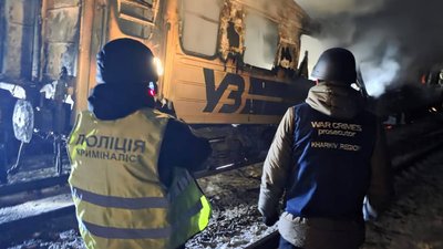 Слідчі біля обгорілого вагону поїзда