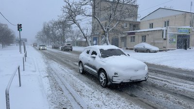 Засніжені автомобілі їдуть вулицями міста