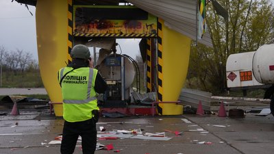 Поліцейськийстоїть біля пошкодженої ударом дрона АЗС у Слобідському районі Харкова