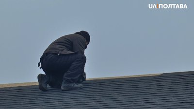 Олег Авраменко кладе бітумну черепицю на трапезну