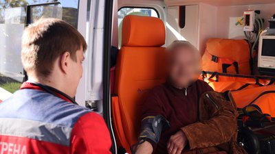 Медик міряє тиск чоловіку