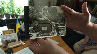 Оксана Півень показує старе фото меморіалу у Болехові