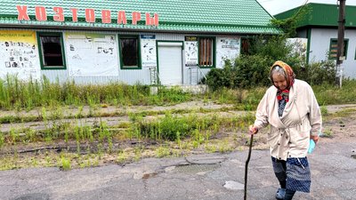 Жінка йде вулицею міста Святогірськ на Донеччині 26 липня 2026 року