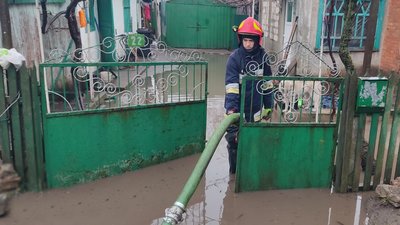 Рятувальник відкачує воду з подвір'я