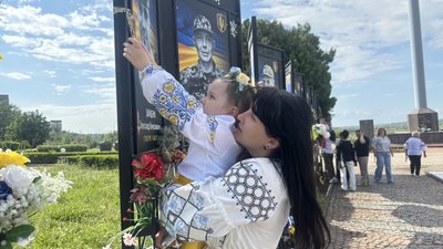 Матір разом з донькою розглядають фотографію загиблого воїна у Південноукраїнську