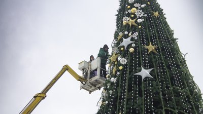 Працівники знімають іграшки з ялинки Працівники знімають іграшки з ялинки