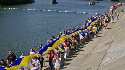 Учасники ходи несуть 100-метровий синьо-жовтий прапор набережною у Вінниці