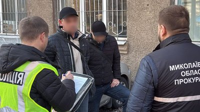 Підозрювані поруч з правоохоронцями під час затримання