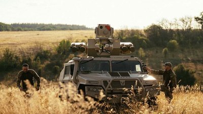 Військові третього корпусу та бронемашина у полі