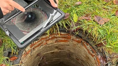 Фахівець Львівводоканалу працює біля відкритого каналізаційного колодязя