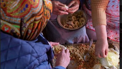 Жінки ліплять голубці. На ніч їх закладають у піч та запікають дев'ять годин. Після розкладають у невеликі відра. Жінки ліплять голубці. На ніч їх закладають у піч та запікають дев'ять годин. Після розкладають у невеликі відра.