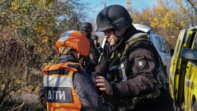 Евакуаційник застібає бронежилет дитині