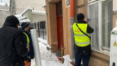 Чоловік закриває плівкою частину вікна