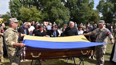 Домовину із тілом полеглого захисника України накривають національним прапором, 2 вересня 2023. Фото: Старокостянтинівська міська рада Домовину із тілом полеглого захисника України накривають національним прапором, 2 вересня 2023. Фото: Старокостянтинівська міська рада