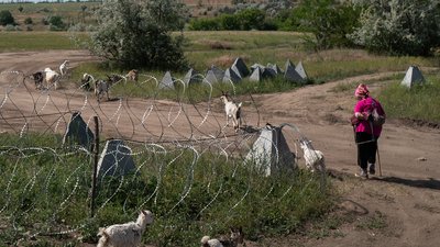 Жене кіз на околиці Костянтинівки повз фортифікацію. Тиждень повномасштабної війни — у фото