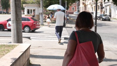 Перехожий у Чернівцях йде з парасолею під час спеки