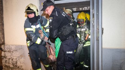Рятувальники виносять жінку з пожежі
