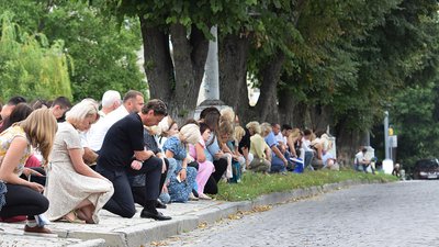 Жителі Кам'янця-Подільського на колінах зустрічають кортеж із тілом полеглого на війні Романа Будовицького. Жителі Кам'янця-Подільського на колінах зустрічають кортеж із тілом полеглого на війні Романа Будовицького.