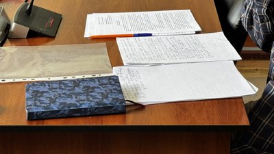 Папери та блокнот на столі у залі суду