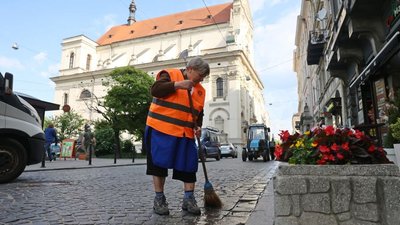 Працівниця комунального підприємства підмітає вулицю