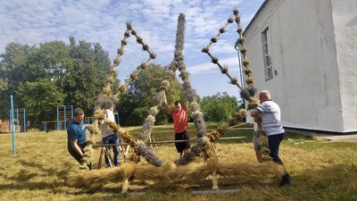 Чоловіки підіймають тризуб з польових квітів та дідухів, 24 серпня 2023, Деражнянська громада.