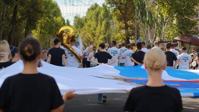 Місцеві жителі урочистою ходою несуть прапор Миколаєва, 13 вересня 2025 року