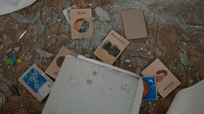 Книги лежать на підлозі з розбитим склом