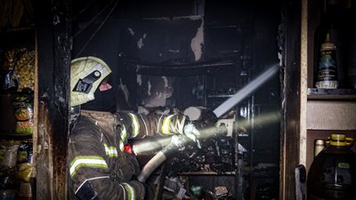 Рятувальник гасить пожежу у магазині в Салтівському районі Харкова