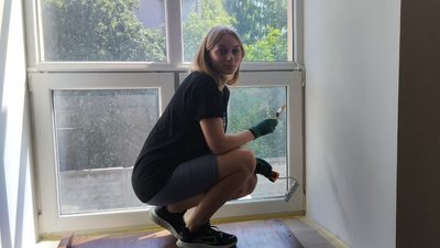 Учасниця програми фарбує укоси вікон Учасниця програми фарбує укоси вікон