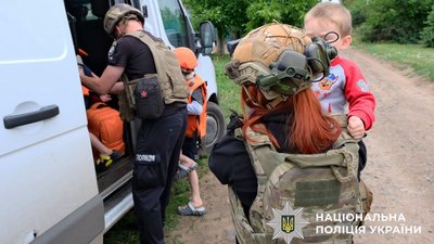 Евакуаційники садять дітей у машини для евакуації