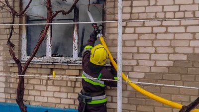 Рятувальник гасить пожежу в будинку