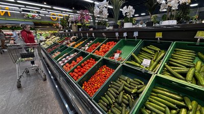 Жінка купує овочі в супермаркеті