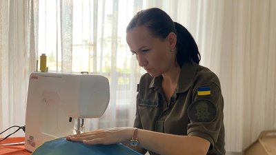 У Тернополі нацгвардійка шиє українські прапори У Тернополі нацгвардійка шиє українські прапори