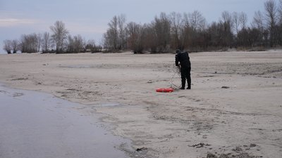 Рятувальник розмотує мотузку на рятувальному колі біля місця для купання, 6 січня 2024 року, Черкаси