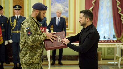 Президент України Володимир Зеленський вручає державну нагороду військовослужбовцю