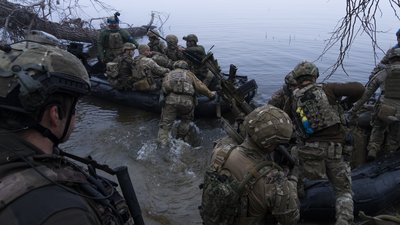 Українські солдати сідають у човни на березі річки Дніпро на передовій поблизу Херсона