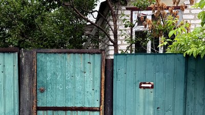 Напис «зайнято, живуть люди» на паркані будинку у місті Святогірськ на Донеччині