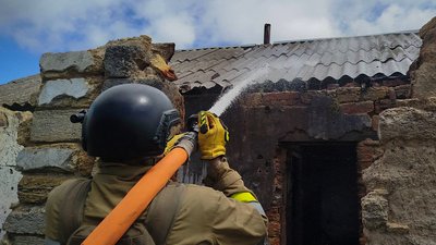 Рятувальник ліквідує пожежу даху