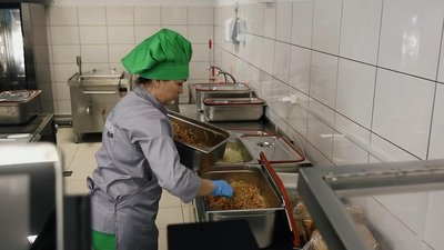 Жінка готує їжу на Фабриці-кухні у Бучі